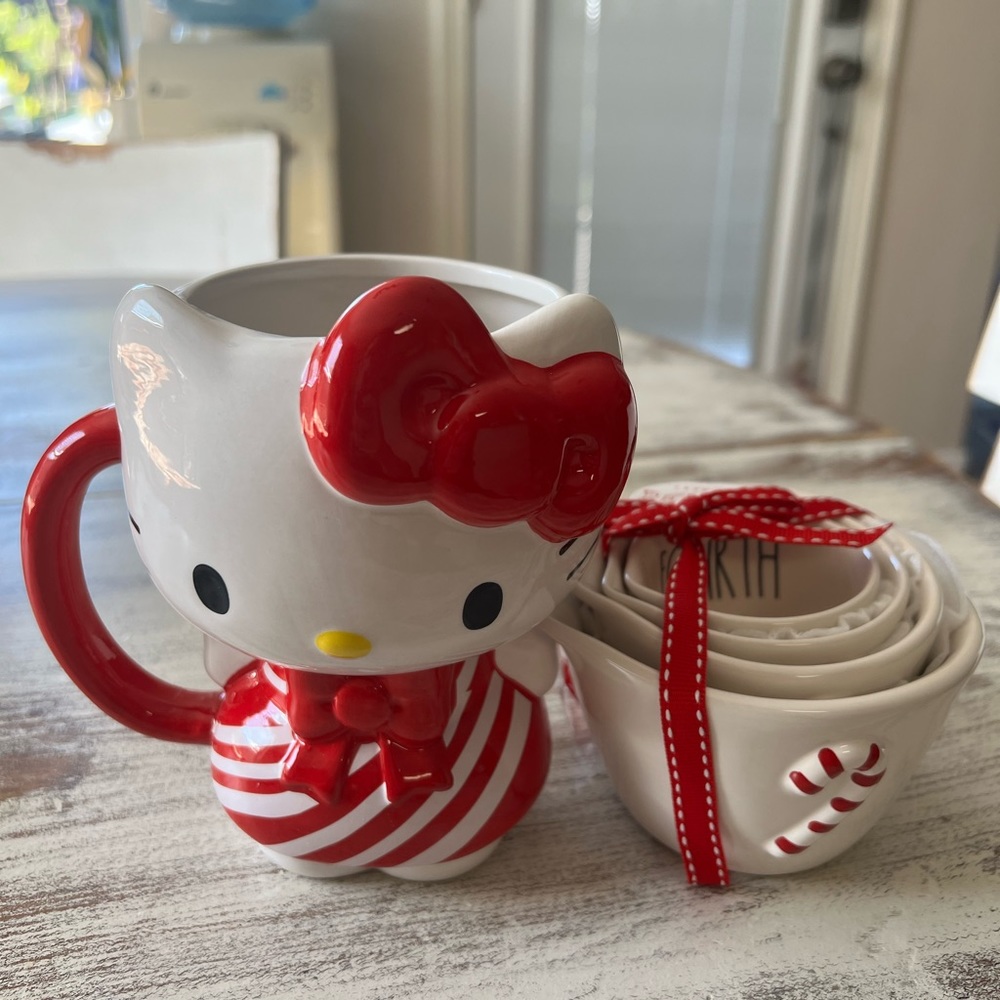 Hello kitty coffee cup and Rae Dunn peppermint measuring cups.